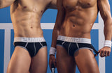 Two models wearing black PUMP! Courtside Full Front Jockstraps on a blue court